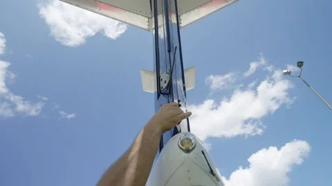Low angle shot of private aircraft tail on background of cloudy sky. Human hand Stock Footage 254950330