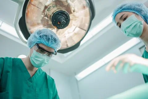 Low Angle Shot of Professional surgeons team performing surgery in operatin.. Stock Photos