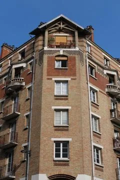 Low-angle shot of a red brick residential building in Paris against a blue sky Photos