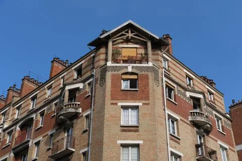 Low-angle shot of a red brick residential building in Paris against a blue sky Photos