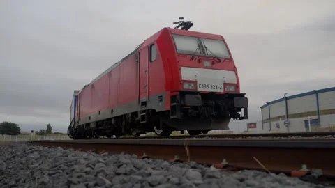 Low Angle Shot of a Red Cargo Locomotive Train on Tracks in Normandy France Stock Footage 337976465