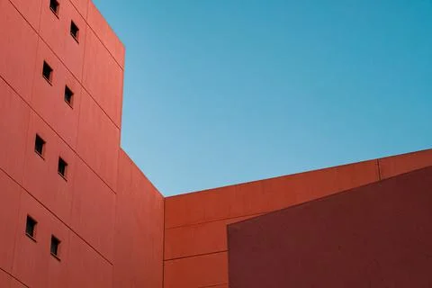Low angle shot of a red-colored building, under the daylight sky Ilustración de archivo