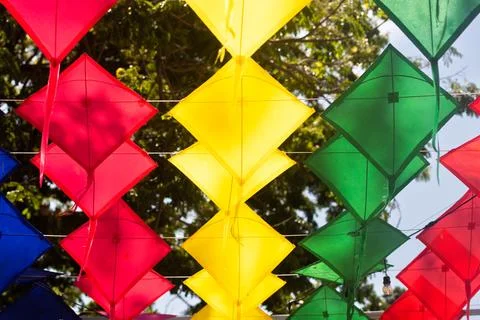 Low angle shot of red yellow green and blue traditional kites hanging in rows Stock Photos
