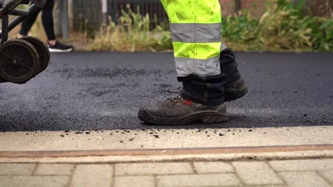 Low Angle Shot of Road Worker Operating Vibrating Asphalt Compactor – 4K Stock Footage 311072922