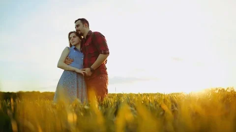 Low angle shot of romantic couple cuddling at bright sunset, holding their hands Video stock 84652298