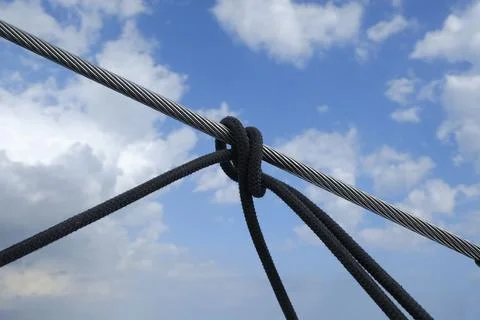 Low angle shot of rope binding against blue cloudy sky background Foto stock