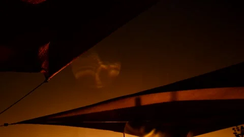 Low angle shot of sails blowing in stormy wind on waterfront at sunset Stock Footage 245948714