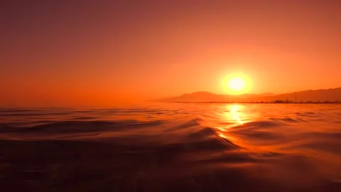 Low angle shot of sea water surface during golden sunset with gentle waves in Stock Footage 337521067
