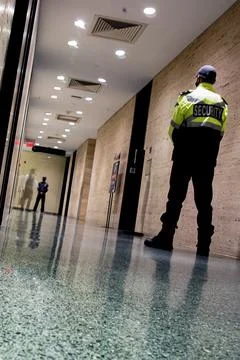 Low angle shot of security guards patrolling inside commercial building Stockfoto's