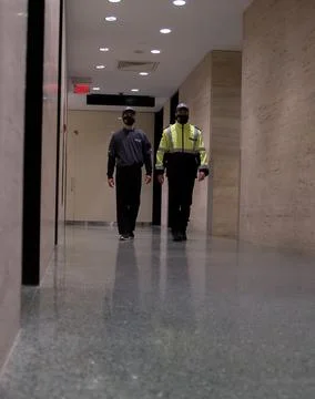 Low angle shot of security guards patrolling inside commercial building Stock Photos