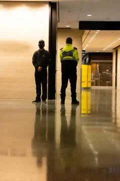 Low angle shot of security guards patrolling inside commercial building Фото