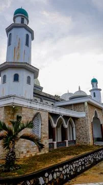 The low-angle shot shows a mosque with a unique architectural style Stock Photos