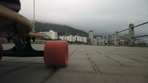 Low angle shot of skateboard rolling down boardwalk next to ocean Video stock 114112039