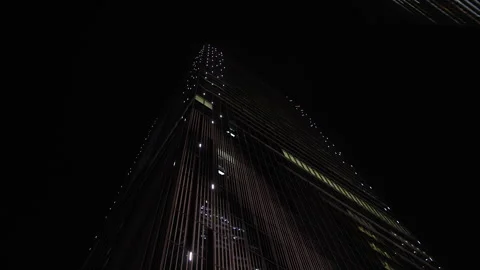 Low angle shot of skyscraper at night with illuminated elevators. Tokyo, Japan. Stock Footage 247963316