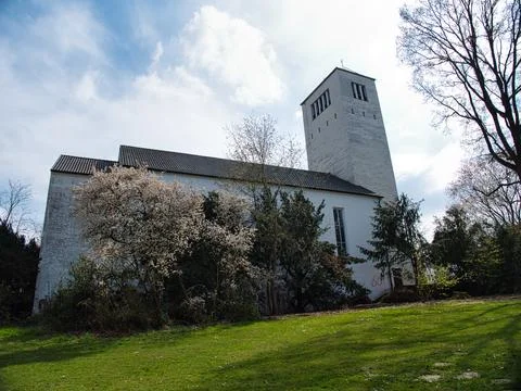 Low angle shot of a small white church surrounded by trees and grass under .. Stock-Fotos
