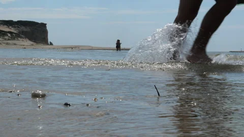 Low Angle Shot of Sparkling Shoreline with Sandbank and Cliffs at Foz do Arelho Видео 340552581