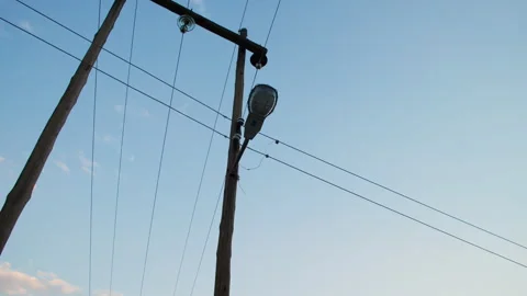 Low angle shot of streetlight with protective cage and intersecting power lines. Stock Footage 242011946