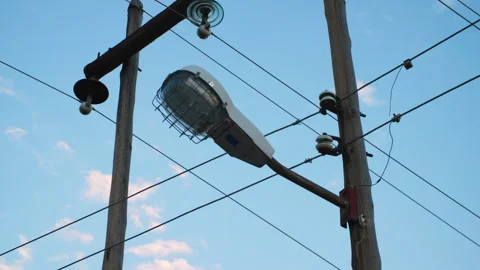 Low angle shot of streetlight with protective cage and intersecting power lines. Stock Footage 242012049