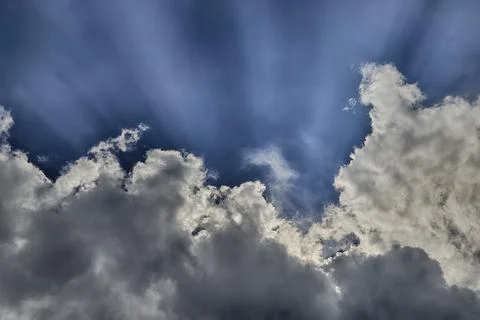 Low angle shot of the sun shining behind the clouds in a blue sky Foto stock