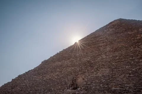 A low angle shot of the sun shining from behind the Great Pyramid of Giza in  Stock Photos