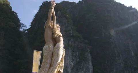 Low-angle shot of sweet couple standing on long tail boat and raise their hands. Video stock 152126752