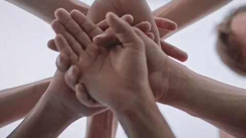 Low angle shot of a team doing a hands in cheer before the big game. Huddle. Stock Footage