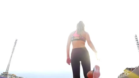Low angle shot of teenager girl athlete stretching before running on a stadium Stock Footage
