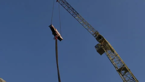 A low angle shot of a tower crane leaving a frame Stock Footage 248289818