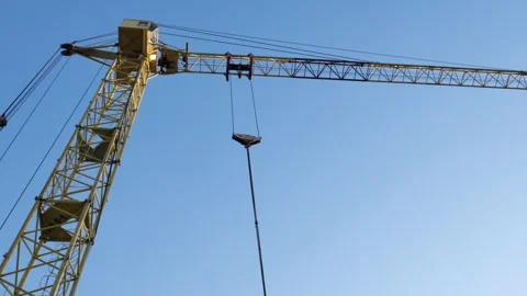 A low angle shot of a tower crane at a construction site Stock Footage 248289955