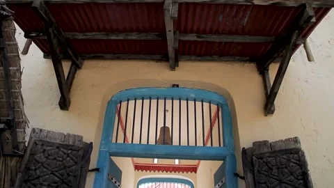A low-angle shot of a traditional building entrance featuring an ornate wooden Vídeos de archivo 345028992