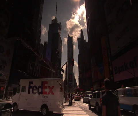 Low angle shot of traffic heading into Times Square, pedestrians walk through Stock Footage 86699709