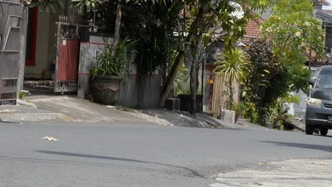 Low angle shot of traffic on a small town road, Bali Stock Footage 140309866