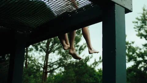 Low-angle shot of an unrecognizable couples bare feet dangling from a terrace Stock Footage 321278869