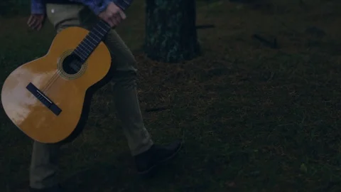 Low angle shot of unrecognizable person holding guitar while wandering in the 스톡 동영상 108731531