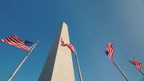 Low angle shot Washington monument in DC, USA, American flags flap below Stock Footage 83179601