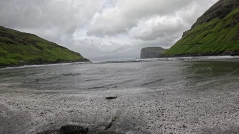Low angle shot at the water edge on Tjornuvik black sand beach, Faroe Islands Stock Footage 339481884