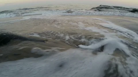 Low angle shot of wave on beach wrapping around camera Stock Footage 41673644