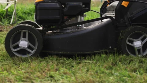 Low angle shot of a wheeled lawn mower. Video stock 316599156
