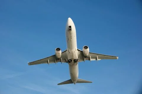 Low Angle Shot of a White Aircraft Soaring Through Blue Sky Stock Photos