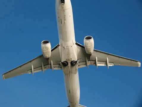 Low Angle Shot of a White Aircraft Soaring Through Blue Sky Stock Photos