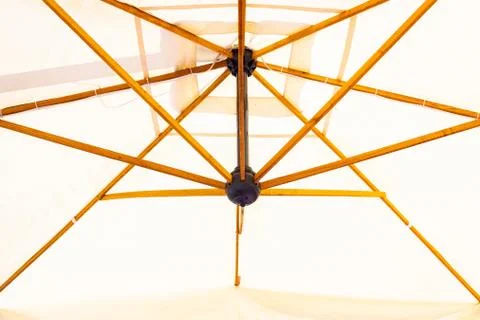 Low angle shot of a white beach patio umbrella  with wooden ribs Photos