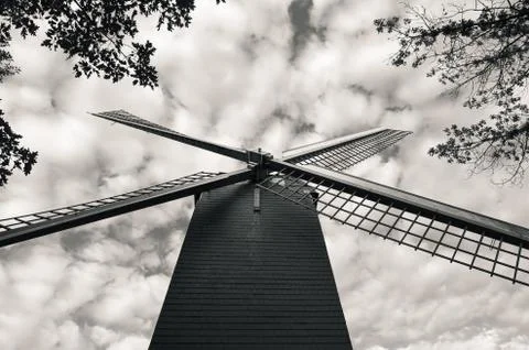 Low angle shot of a windmill against a cloudy sky in black and white Stock Photos