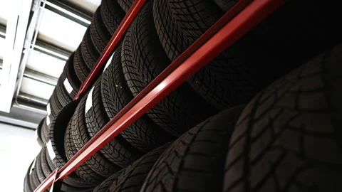 Low Angle Shot of Winter Tires Stacked on High Red Shelving Stock Footage 318309632