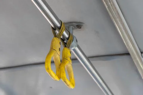 A low angle shot of a yellow-colored handle of a public bus in India after th Photos