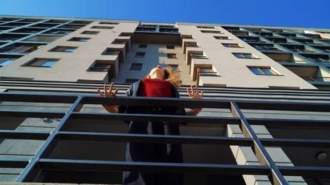 Low angle shot of young blonde woman dancing near metal railings on city street Stock Footage 106052696