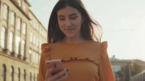 Low angle shot of young long-haired woman walking down the busy city-street Stock Footage 91994133