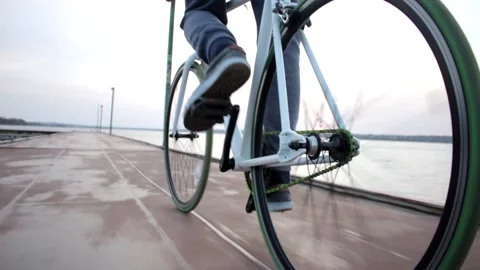 Low angle shot of young man ride bike on river landscape, healthy sport activity Stock Footage 132673958