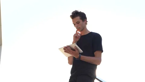 Low angle shot of young man doing video chat on digital tablet against sky on Stock Footage 136944801