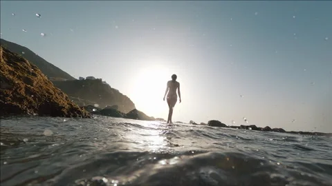 Low-angle shot of young sexy beautiful woman wearing bikini swimwear walking on Stock Footage 160252306