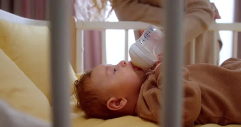 Low angle side shot of unrecognizable female's hand holding bottle with milk Stock-Footage 147932864